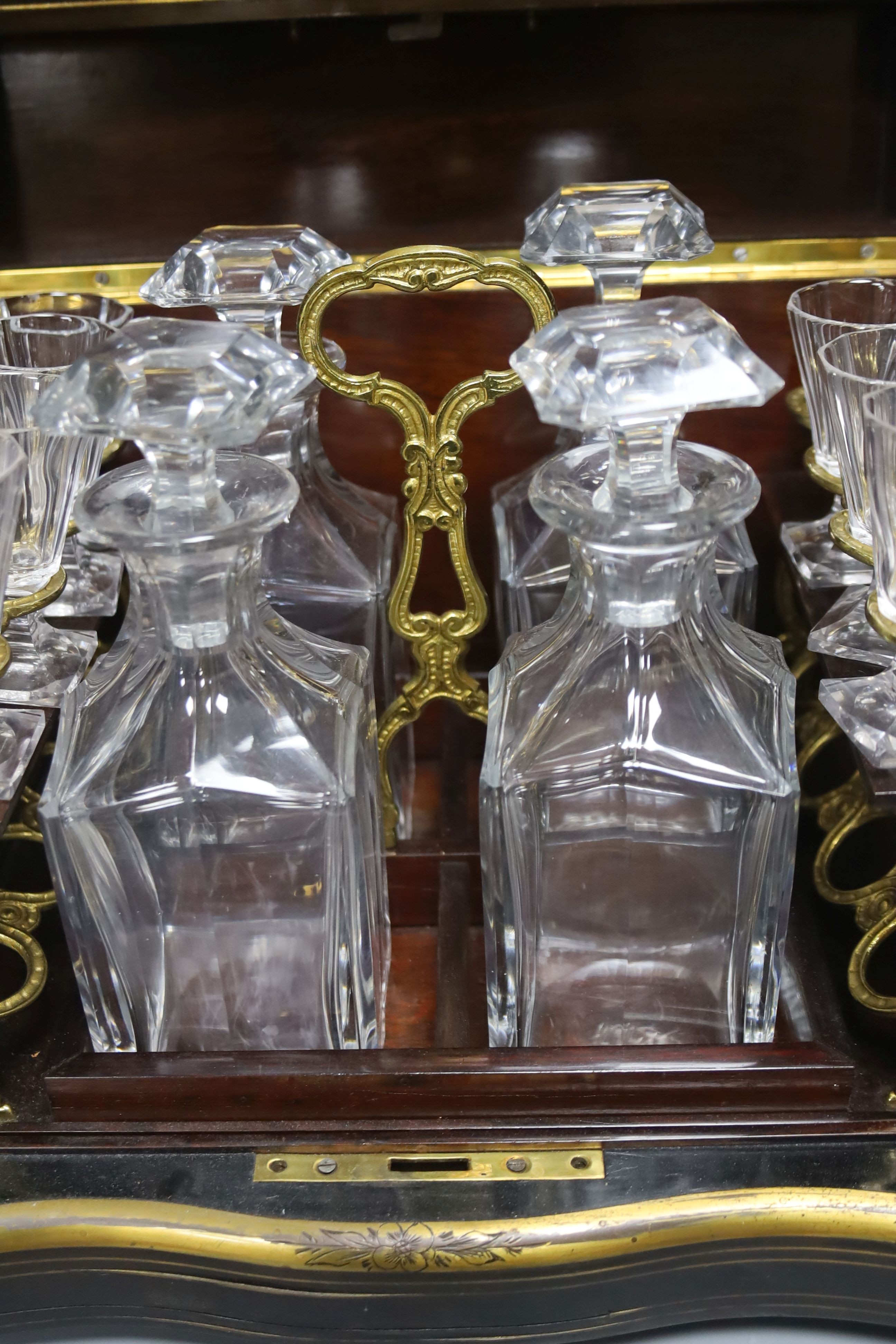 A mid-19th century French ebonised and brass-inlaid decanter case, fitted four decanters and seven glasses on removable tray (incomplete), W 35cm